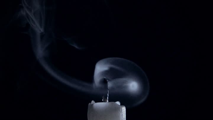Candle smoke folding back into the wick